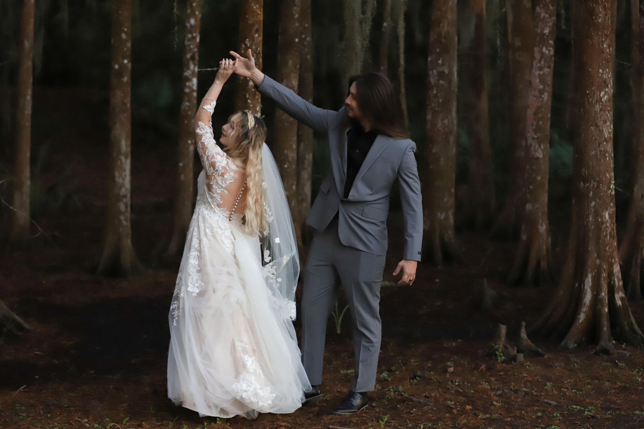 Couple sharing a twirl among the pines — engagement photography in Acadiana by AG Photography
